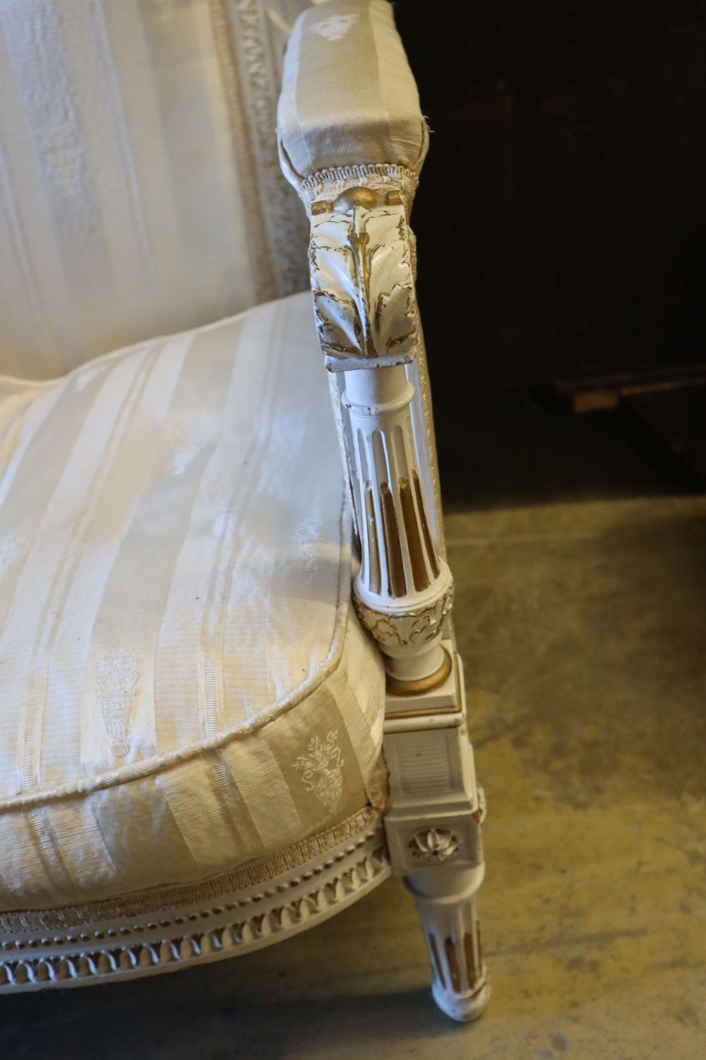 An early 20th century parcel gilt white painted canapé, width 128cm